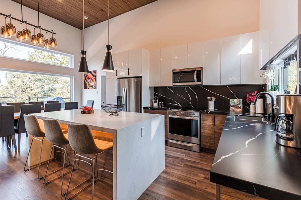 Spacious kitchen with island seating, modern appliances, and wood floors