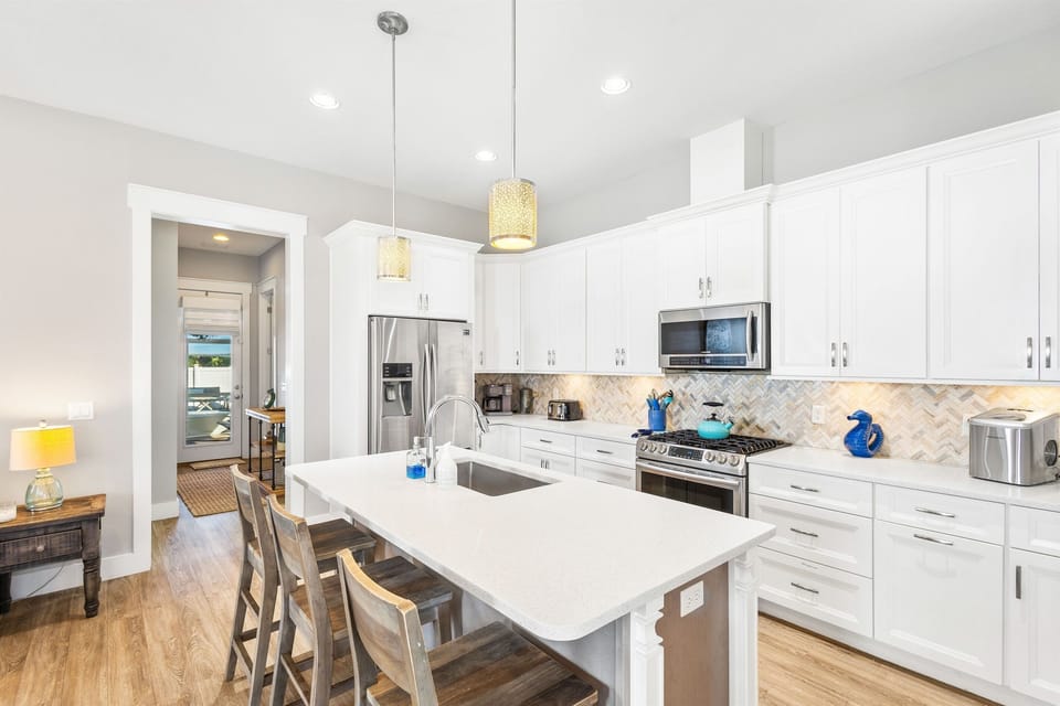 Cook memorable meals in your gourmet kitchen featuring pristine white cabinetry, quartz countertops, and premium stainless steel appliances.