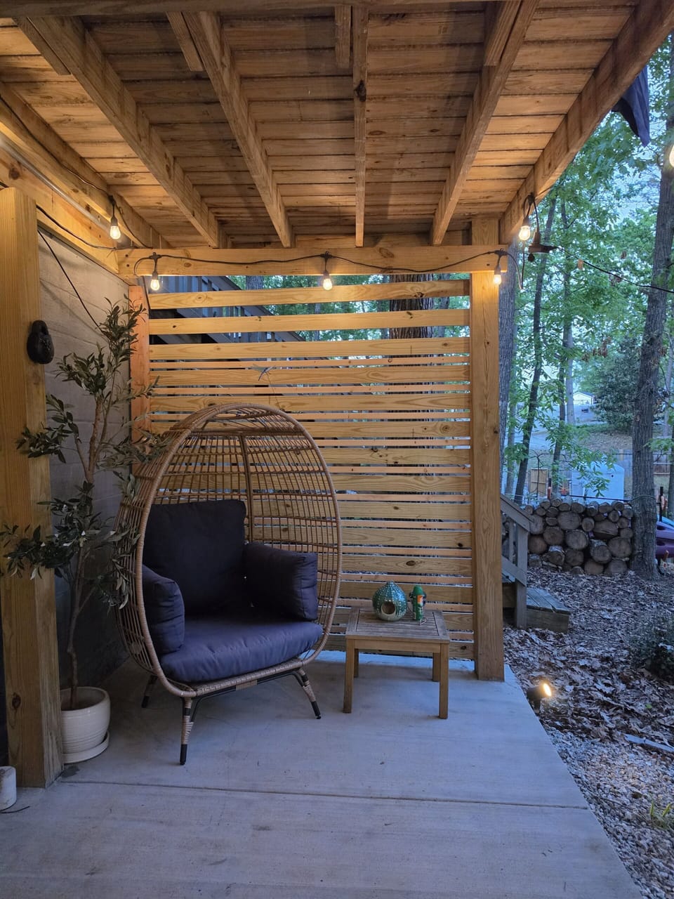 Cozy private patio nook with hanging chair and warm ambient lighting