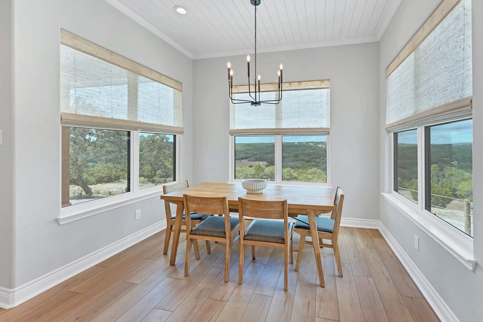 The dining room is wrapped in Hill Country views