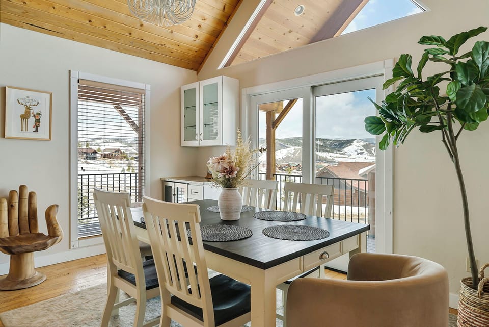 Dining area with seating for 6, deck access, and wine fridge.