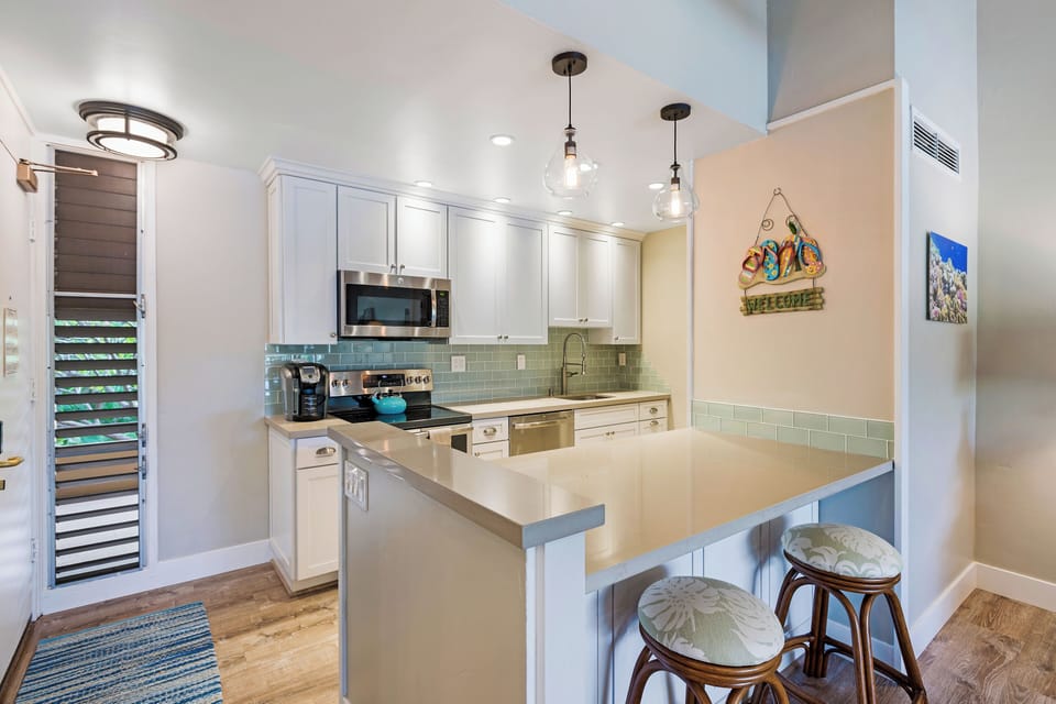 Maui Kaanapali Villas 292’s kitchen has bar seating, stainless steel appliances, and island charm.