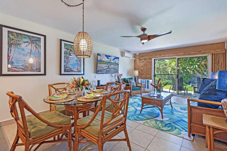 The open-concept dining and living area at Kahana Sunset B4B features tropical décor and ocean views from the lanai.