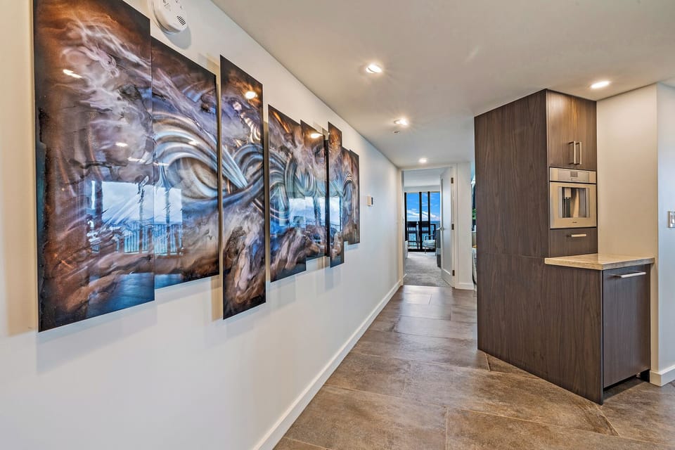 Art-lined hallways at Kaanapali Shores 702 lead you toward epic ocean views.