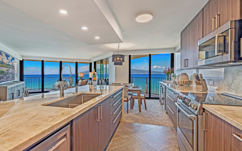 Kaanapali Shores 702’s kitchen features modern appliances, island seating, and ocean views.