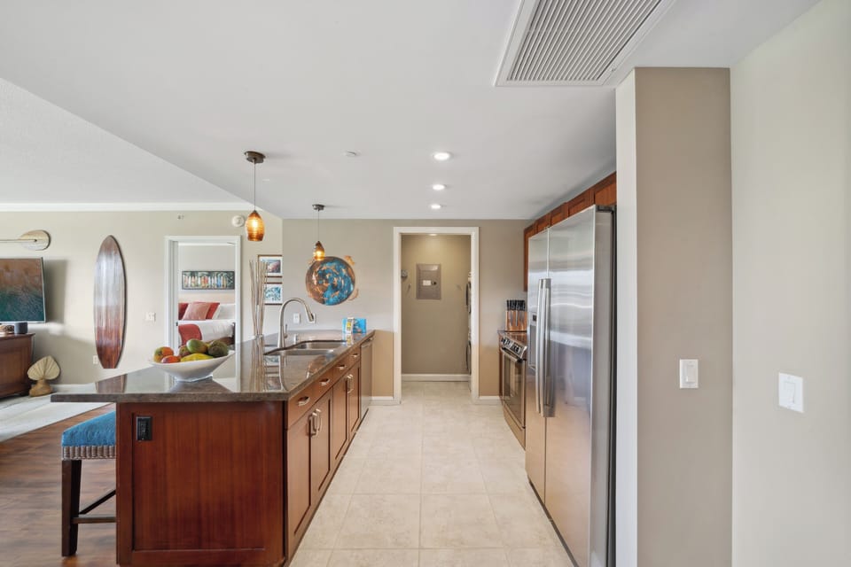 A bright galley-style kitchen at Honua Kai Konea 204 connects beautifully to the rest of the open-concept home.