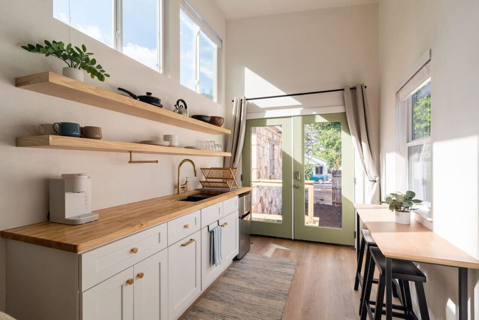 French doors further opening up the space with black-out curtains to maximize space; cute dining space for a shared meal or a great remote working station