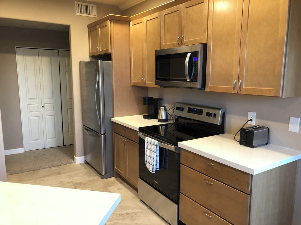 Kitchen with fridge, stove, microwave, Keurig coffee maker, kettle and toaster