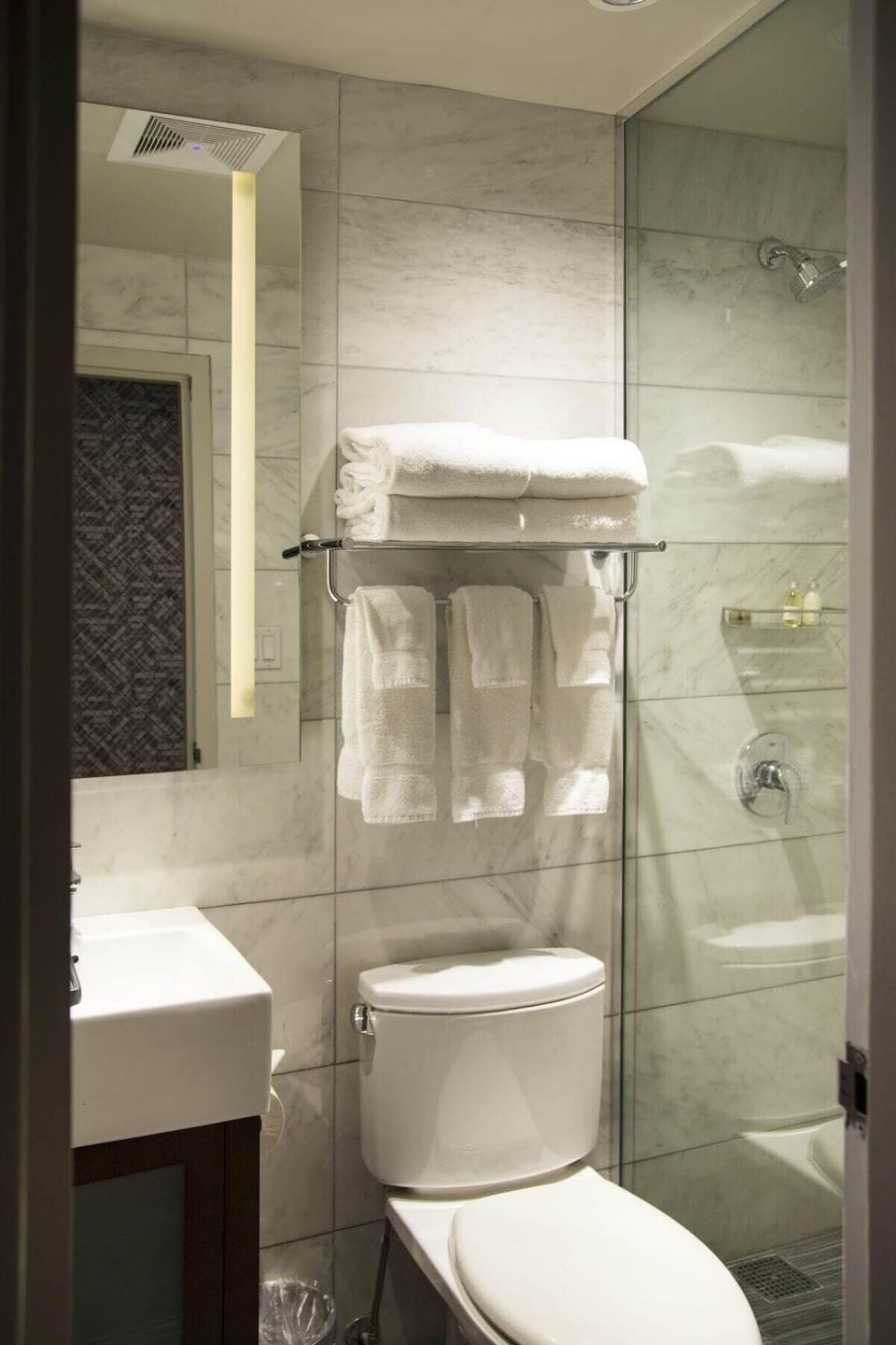 Refresh under a sleek glass shower with fluffy towels.