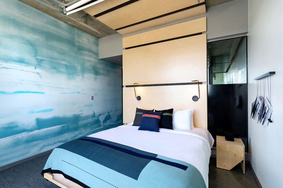Drift off beneath curated art and warm, modern bedside lighting.