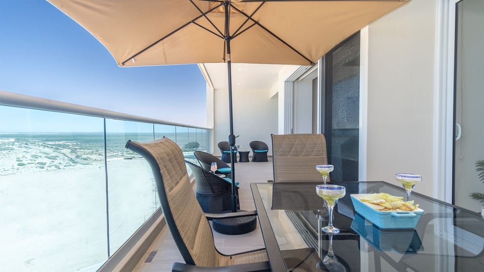 A large glass topped dining table adorns the balcony