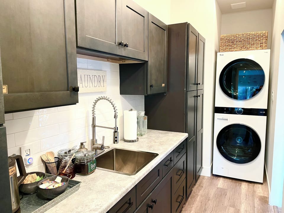 Hidden pantry houses stacked washer/dryer and coffee bar