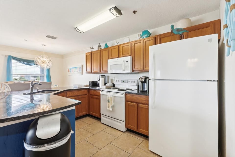 - Fully equipped kitchen with appliances and ample counter space  
- Warm cabinetry paired with bright accents adds coastal style  
- Ready for home-cooked meals and convenient guest experiences 