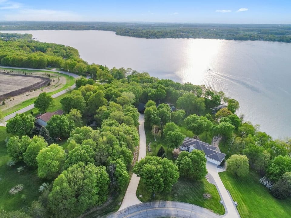 Aerial view of the long driveway (in the middle), neighborhood, and lake