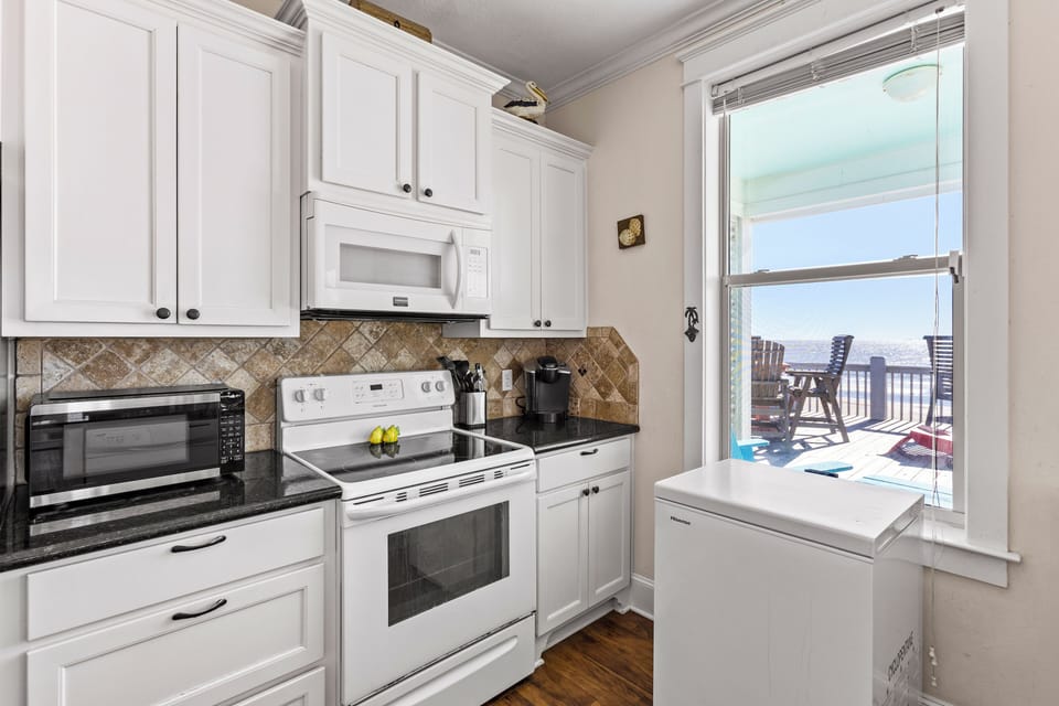 Cook with ease in the fully equipped kitchen, featuring modern appliances, plenty of counter space, and all the essentials for your culinary creations.