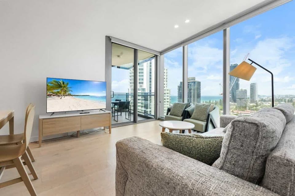 Spacious living room with a high ceiling, floor-to-ceiling windows, and an amazing Southeastern coastline view.
