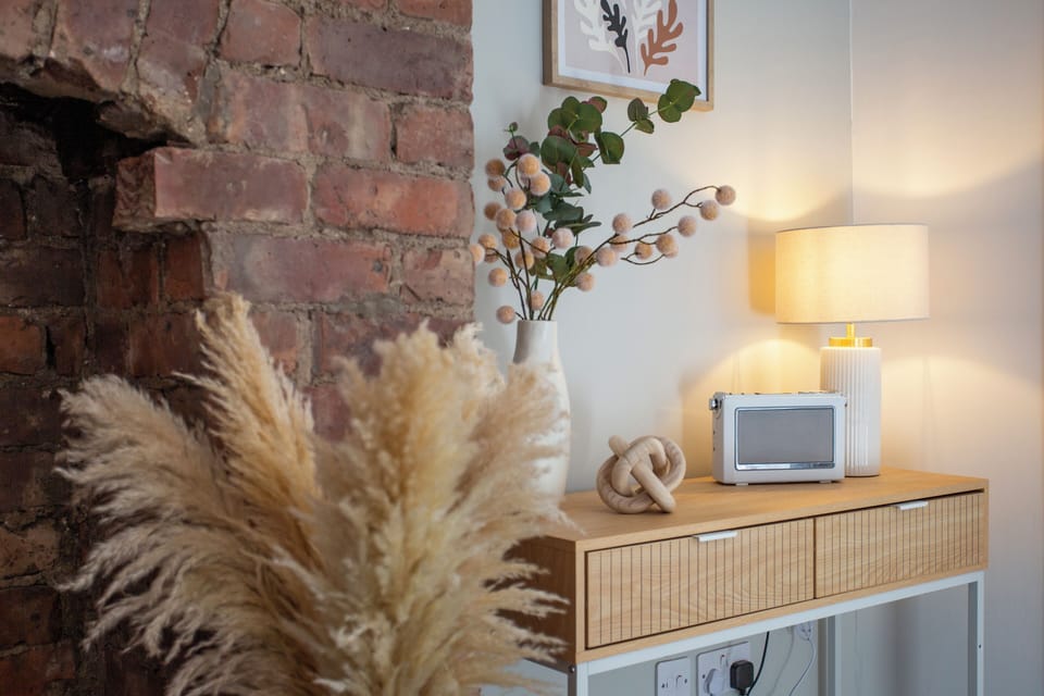 The arrangement of pampas grass in the foreground adds a natural, bohemian touch, creating a warm and inviting atmosphere. 
