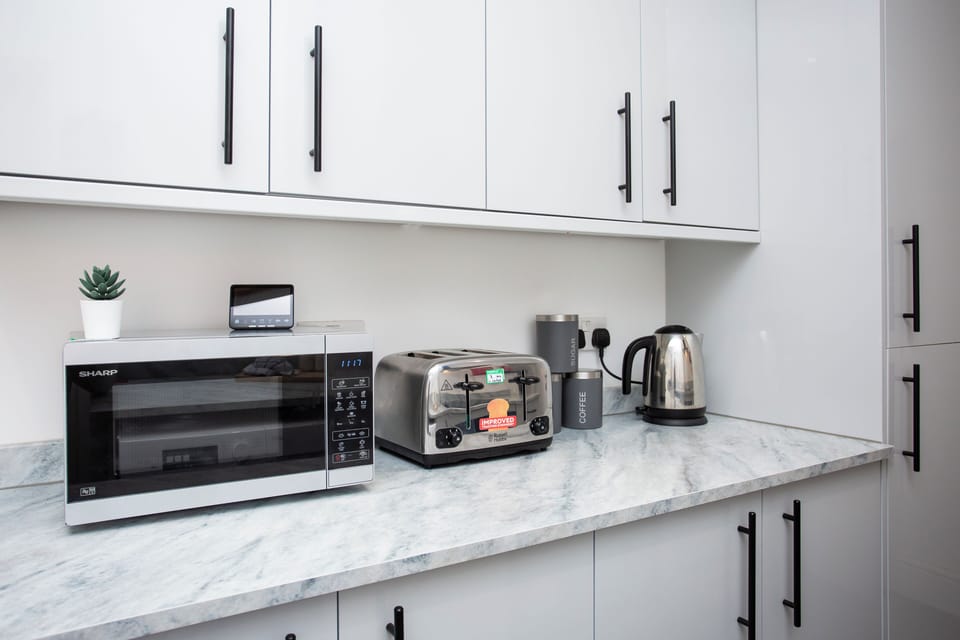 Equipped with essential modern appliances, the kitchen includes a microwave for quick heating and defrosting, making it easy to prepare meals in no time. 