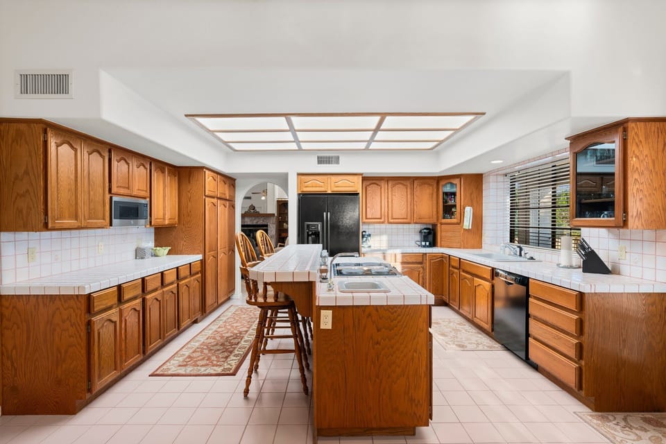 A kitchen where warmth meets style, with wooden cabinets and modern appliances, offering the perfect recipe for home-cooked memories. This inviting space is perfect for culinary adventures and cozy gatherings, making every meal a special occasion. 🍽️✨