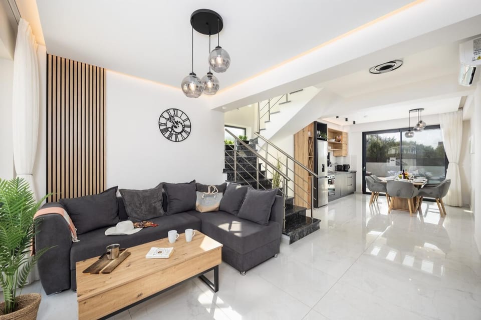 Open-plan living room with sofa, dining area, kitchen, A/C, WiFi internet, and satellite TV