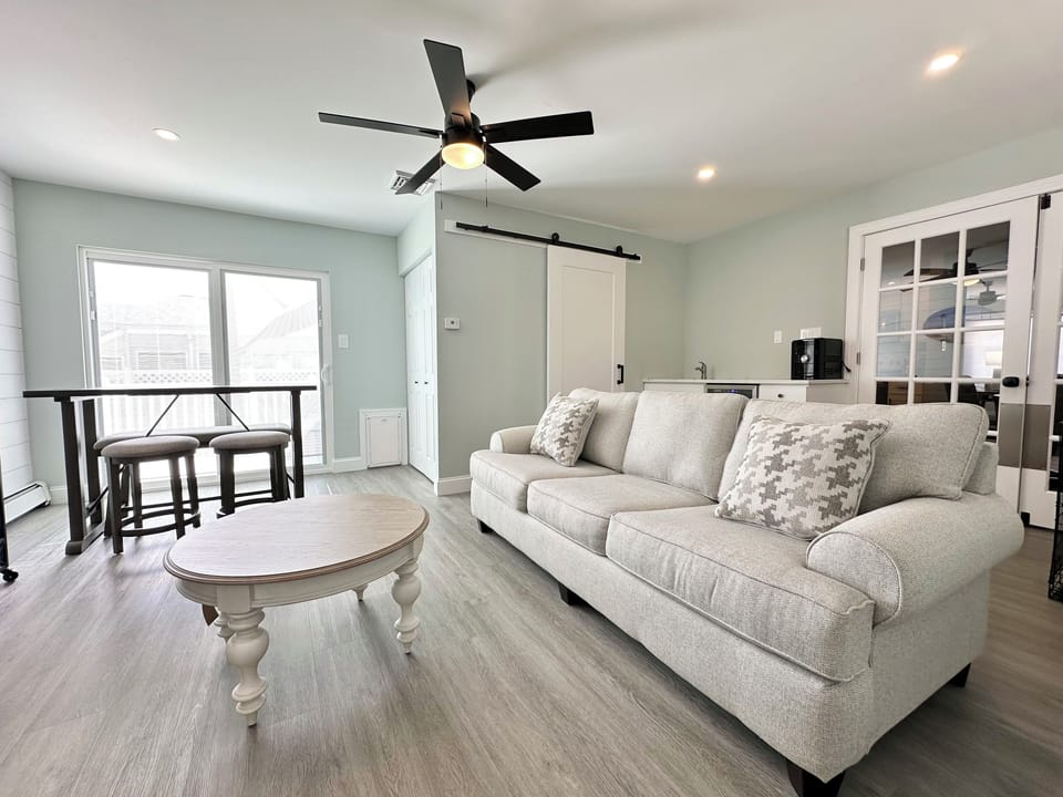family rooms leads to outdoor deck and fenced in backyard