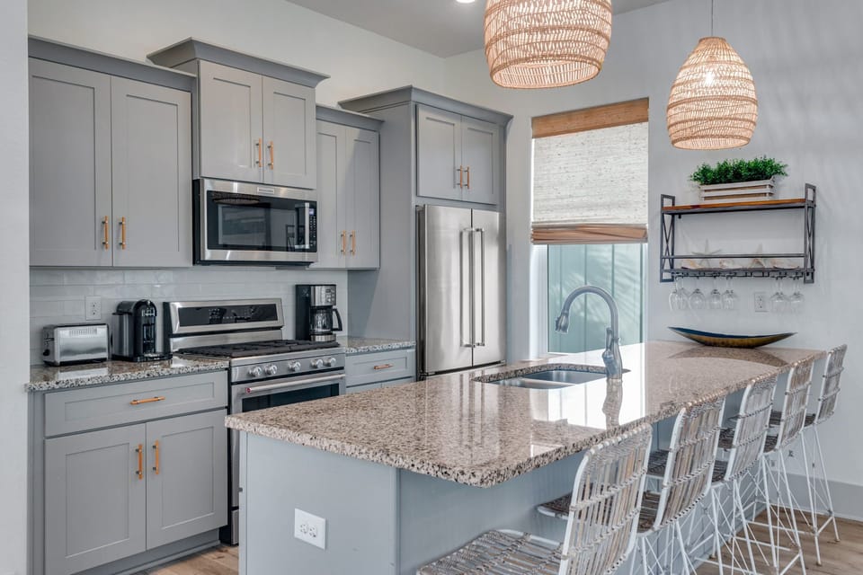 Stocked kitchen with countertop bar seating for four. 