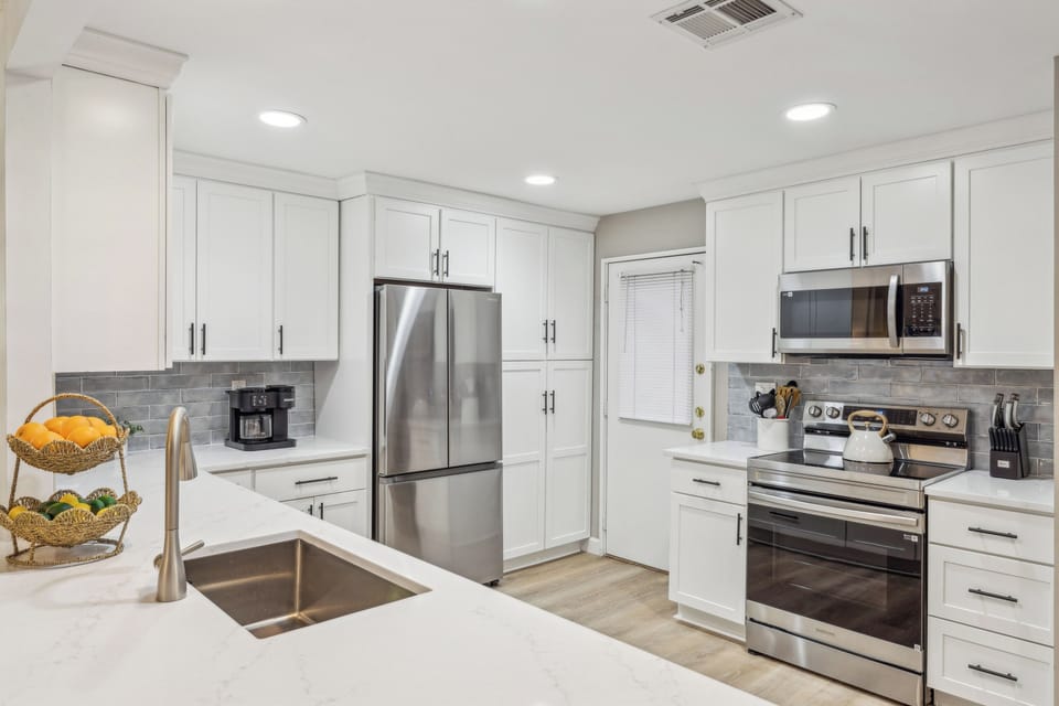 Fully stocked kitchen with stainless steel appliances.