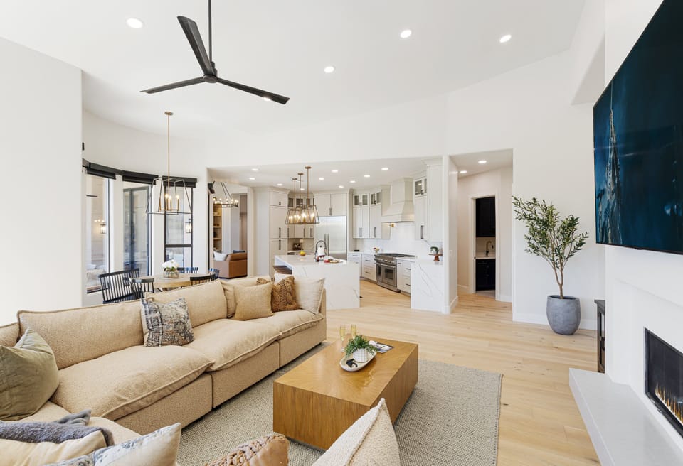 Primary Living Area with designer furnishings, smart TV, fire place, dining table with seating for 6 guests, and access to the backyard.