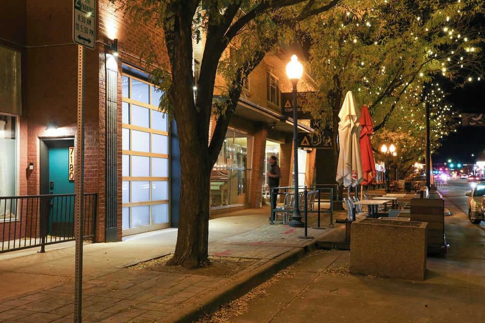 Nighttime view of the garage door and Audacity Wine Bar