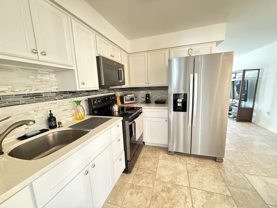 Kitchen: refrigerator, stove, oven, microwave, sandwich maker, tea kettle, pots