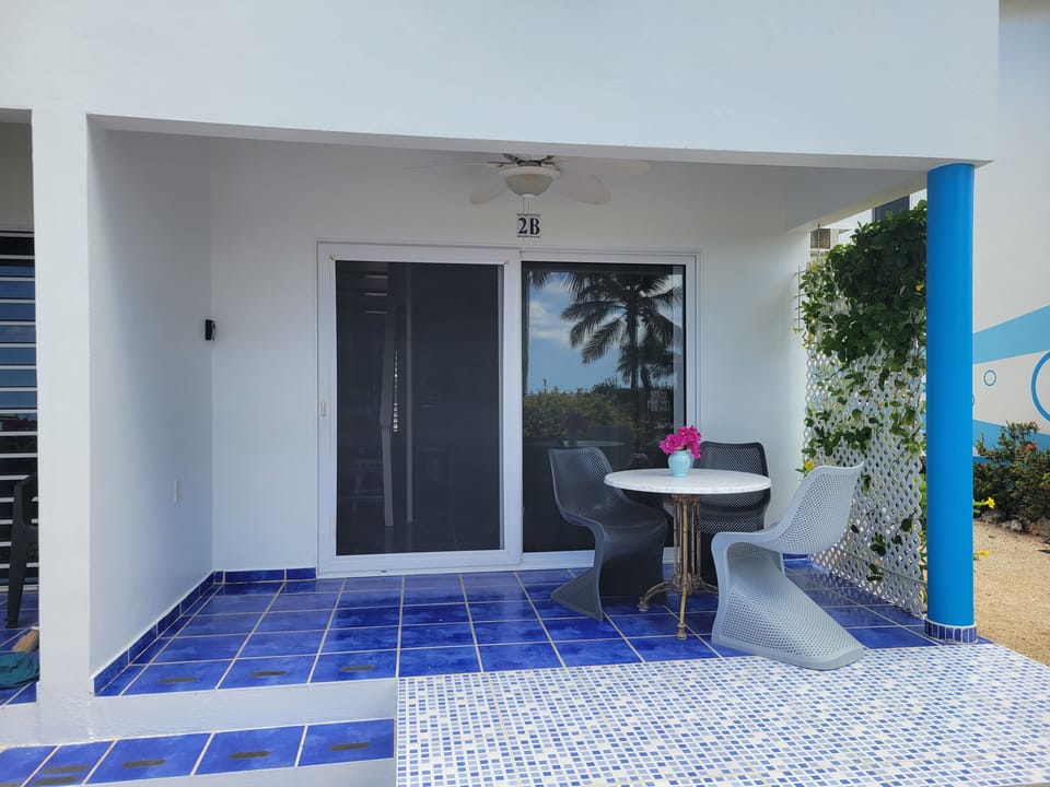 Lower terrace with dining table, 3 chairs, privacy lattice on left side