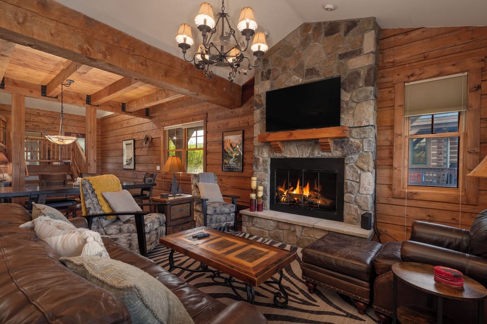 - Cozy living room with stone fireplace and wood beams   - Plush seating and smart TV for relaxing nights indoors   - Rustic cabin charm with warm lighting and decor