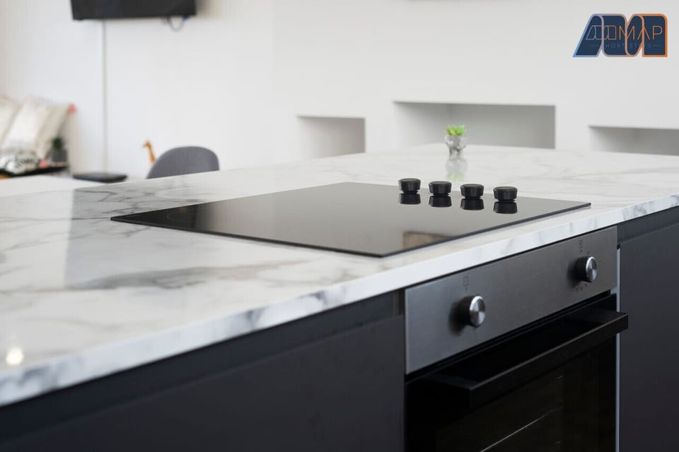 Cook in style with this sleek, modern kitchen featuring a marble countertop and state-of-the-art appliances.