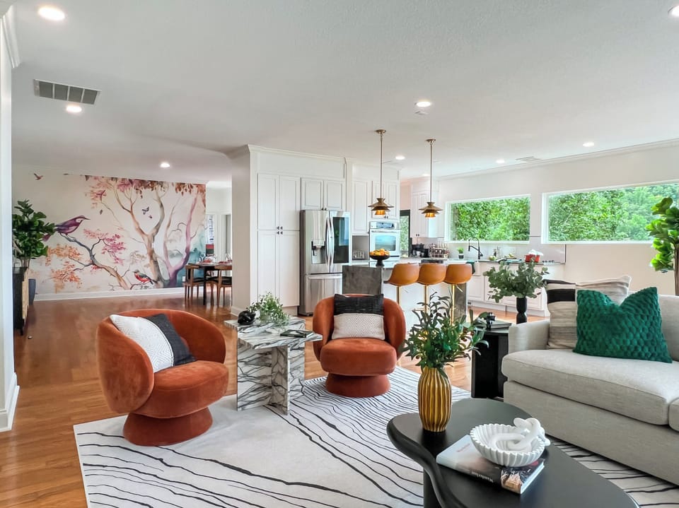 The stylish living room opens up to the kitchen and dining areas.