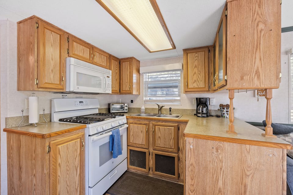 A closer look at the kitchen featuring the oven, microwave, and sink, perfect for preparing meals during your stay.