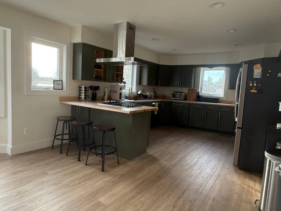 Double oven, cooking range, and bar top seating in the kitchen
