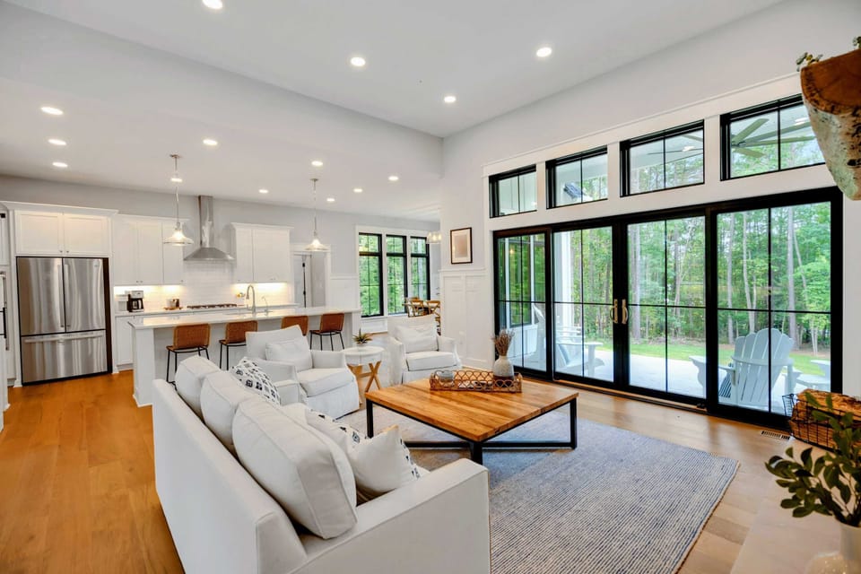 Bright and airy living room featuring a cozy fireplace, stylish furnishings, and large windows for natural light.