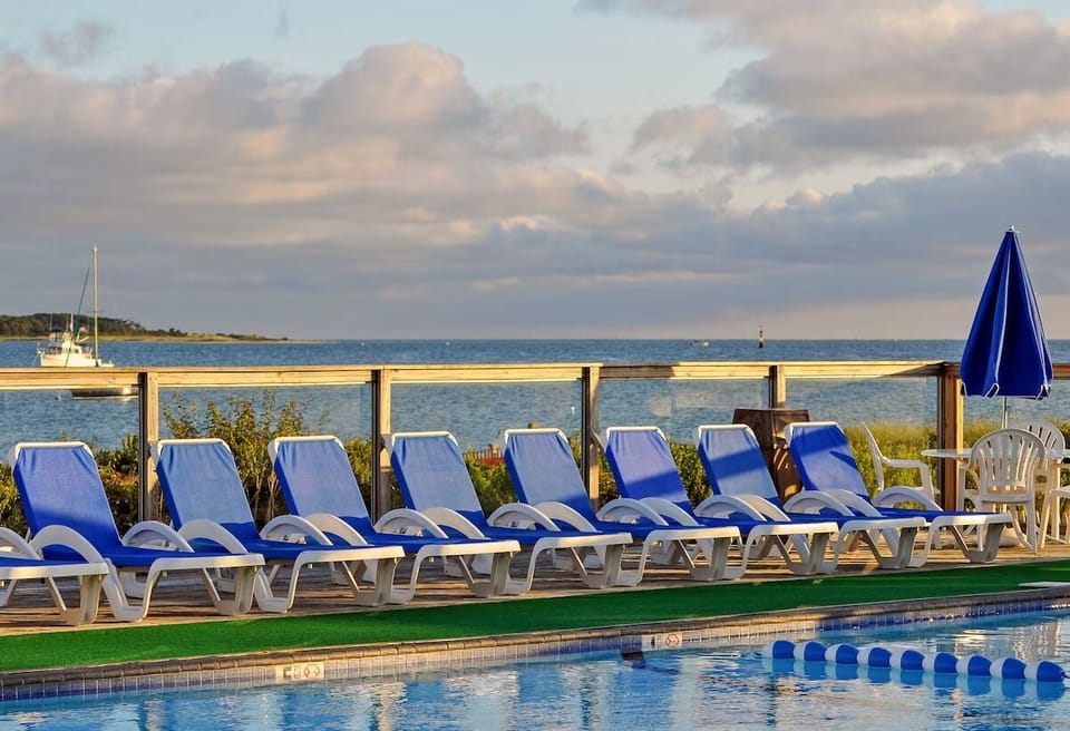 Lounge in golden-hour light beside the shimmering waterfront pool.