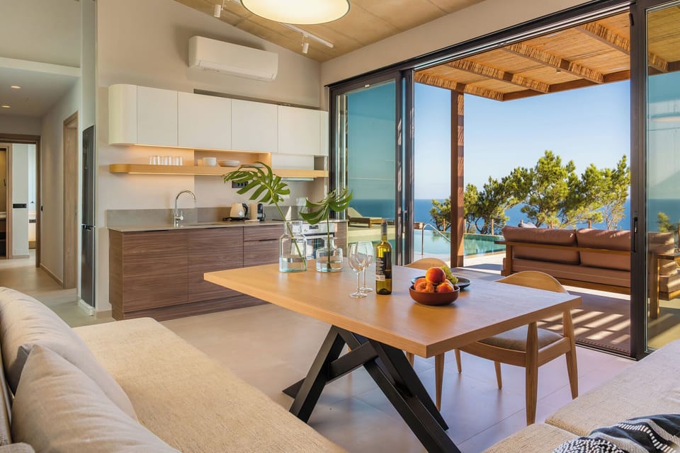 The living room features a 32” Smart TV, a corner sofa, accompanied by a dining table, and a variety of board and card games