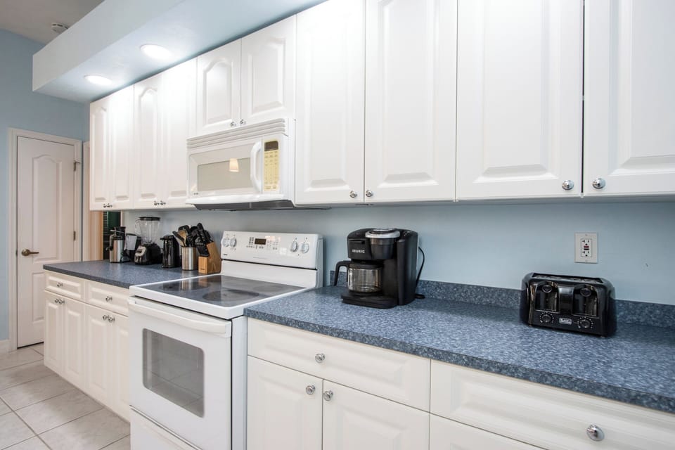 This traditional kitchen showcases white cabinets and appliances, creating a bright and cohesive cooking space