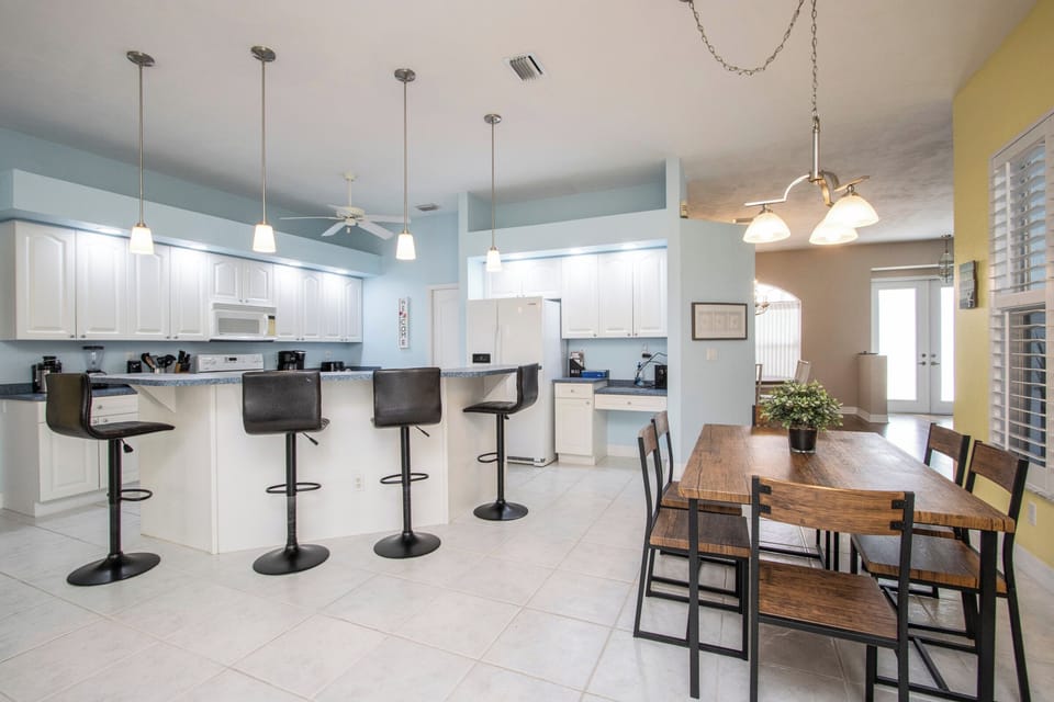 Enjoy a bright and functional space where the kitchen flows into the dining area, complete with bar seating at the countertop and a table with chairs for group dining