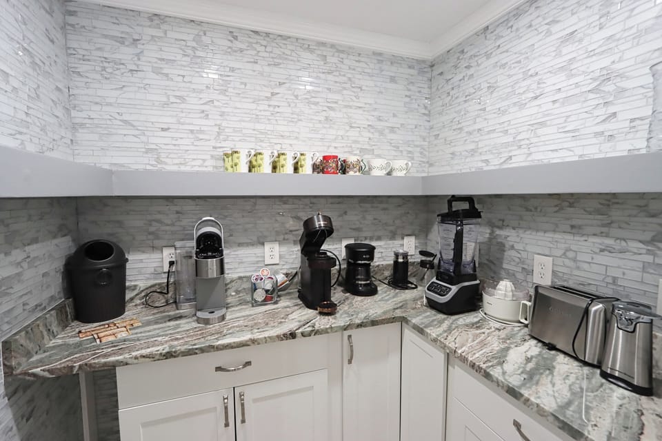 The butler's pantry is stocked with cabinets, granite countertops, and small appliances like a coffee maker, toaster, and blender—perfect for meal prep and keeping the kitchen organized.