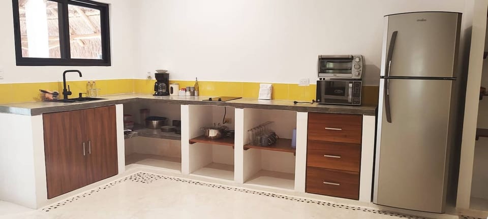 Kitchen with two burner stove, electric oven, coffee maker, microwave full refrigerator