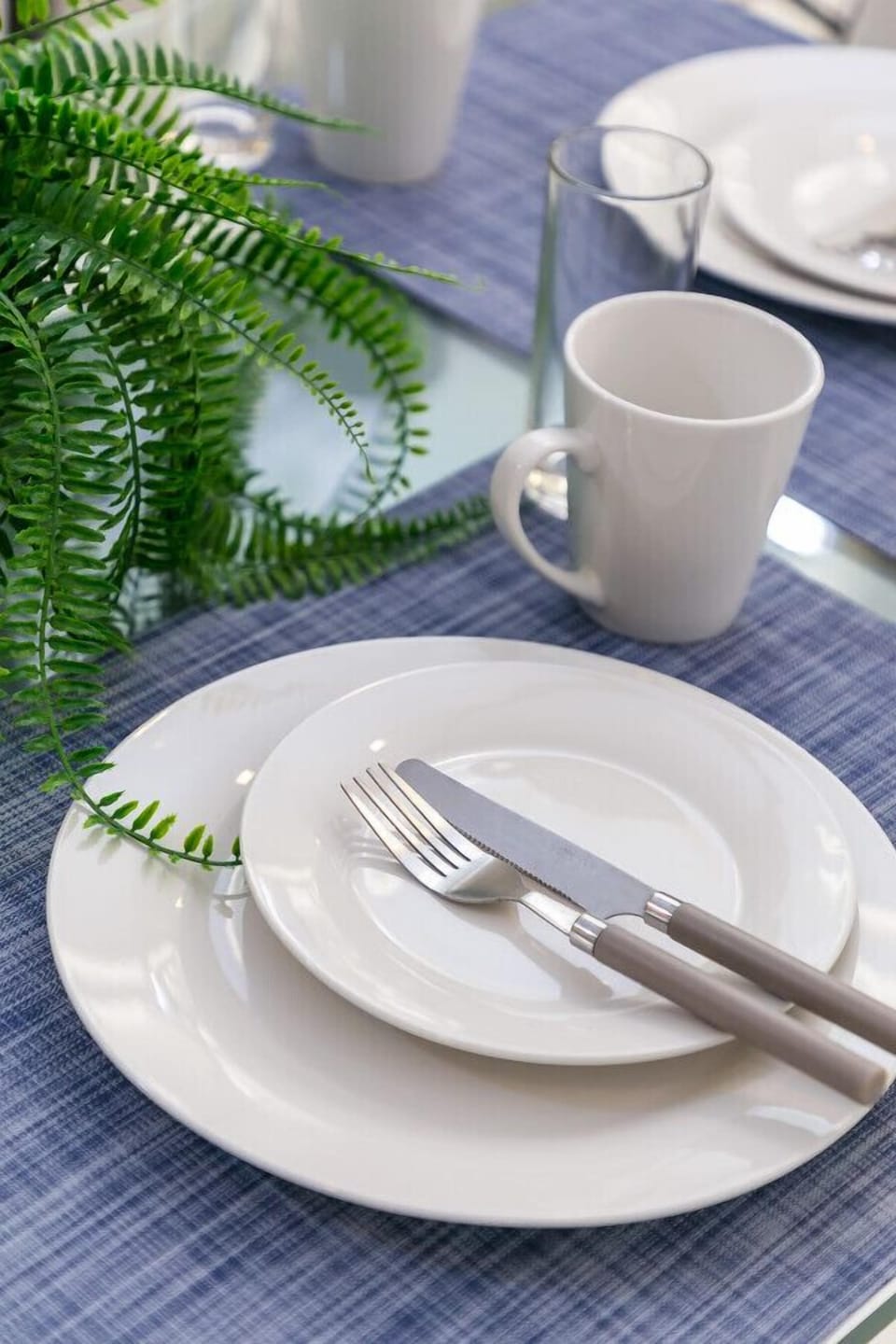 Simple place setting w/ white dishware & mug, ready for a relaxed meal