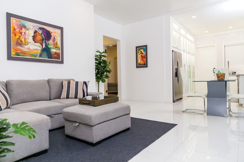 Spacious living room w/ plush sectional, colorful artwork & open flow to the kitchen