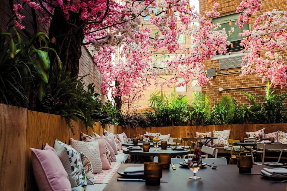 Dine beneath pink blossoms in a lush, romantic hideaway.