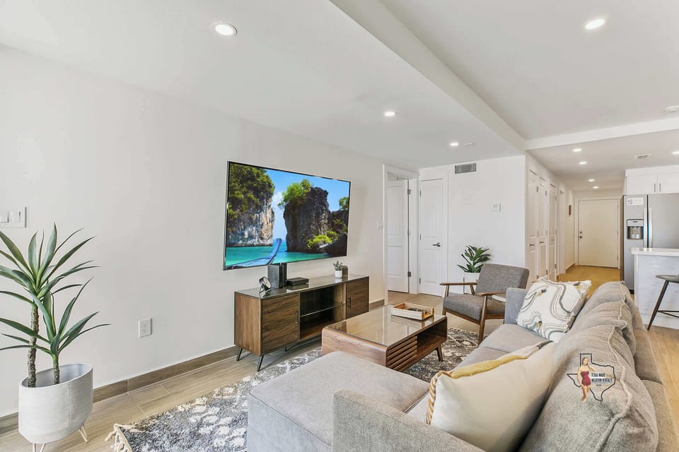 The living room area features a plush sofa facing a flatscreen Smart TV