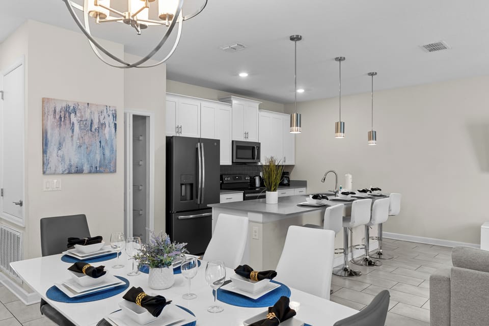 Your modern kitchen flows seamlessly into an elegant dining space, where you'll enjoy meals surrounded by sleek pendant lighting and contemporary style.