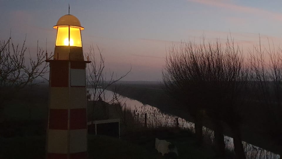 's Avonds brandt de vuurtoren in de boomgaard.