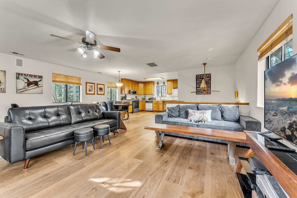 Living Room: Open layout, 2 couches, 2 reclining chairs, 50” Smart TV, wood-burning fireplace, ceiling fan
